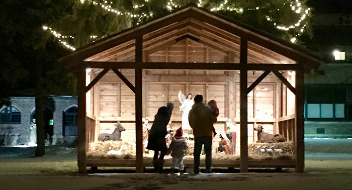A young family stopped by to visit the nativity scene. 