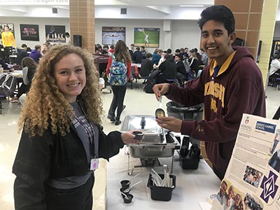 Margaret Musolf '20 tastes traditional Ethiopian food, served by Ethan Thompson '20, President of the Twinning Club.