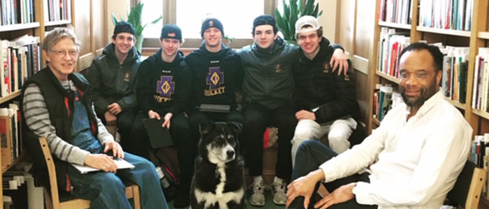 Hockey players met with Greg Poferl '64 and Clarence White at the East Side Freedom Library. Photo courtesy of ESFL.