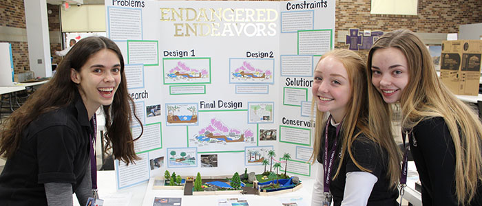 Sophomores Allie Sowatzka, Avery Cavanaugh, and Chloe Anderson show off their exhibit design.