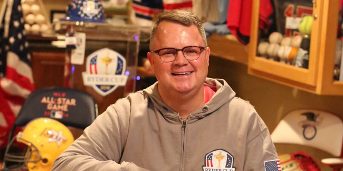Joe Gallagher ’82 sits in his basement among a very impressive, and likely unparalleled, private collection of sports memorabilia. Among items such as the 2016 Ryder Cup podium, uniforms from Paul Molitor ‘74 and Joe Mauer ’01, and basketballs from The NBA Jam Session, Joe has collected the seats from All-Star Games, bats from homerun derbys, and so much more. His bobblehead collection features over 300 different athletes. Of particular note, the Raiders football helmet is front and center.