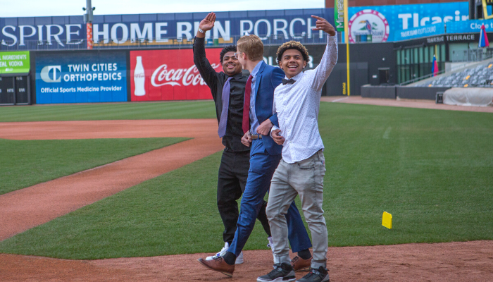 Cage Linton '21, Dante Maietta '21, and Marselio Mendez '21 wave to the crowd during the Grand March.
