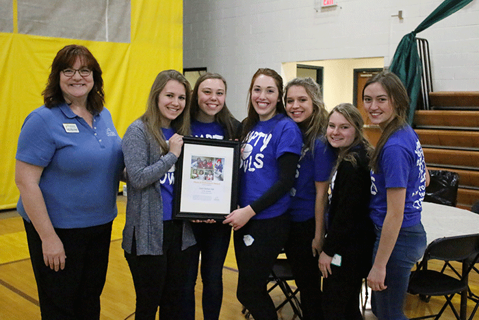 Cindy Seller Roach of Heifer International presents plaque to senior student volunteers.