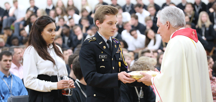 Fr. Pat Kennedy'69 and CDH students celebrating Mass on the CDH campus.