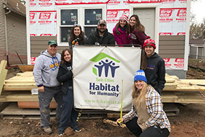 Mr. Gleich, Ms. Mongoven, and Mr. Macken lead a group of students at Habitat for Humanity.