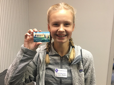 Tyler Mader of Holy Spirit visits CDH and receives her new Future Raiders Club ID card.
