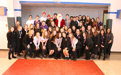 Students gather with Santa for a photo.