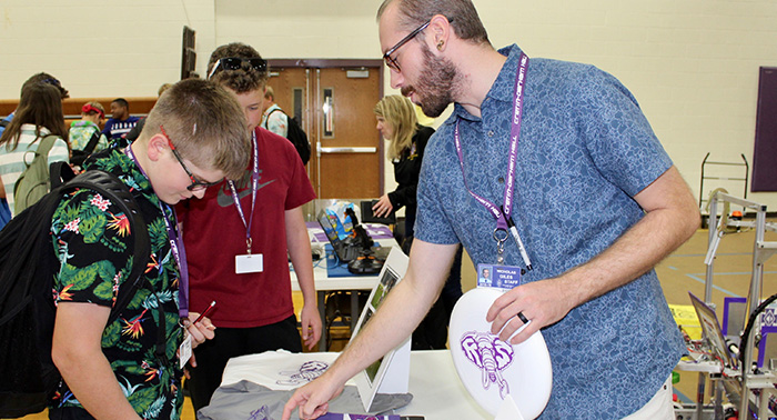Mr. Giles explains the Ultimate Frisbee team to an interested student.